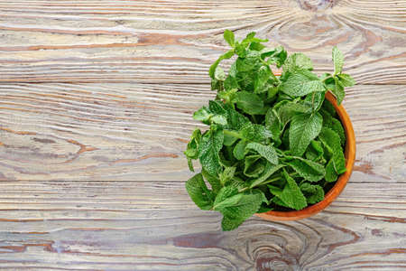Fresh green mint in bowl on wooden backgroundの写真素材