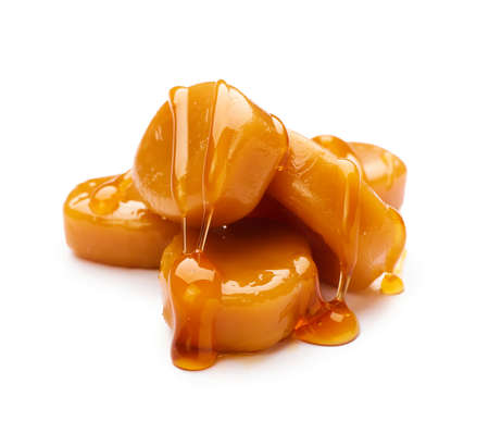 Tasty caramel candies isolated on whiteの写真素材