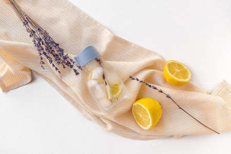Bottle of lavender infused water with lemon on light tableの写真素材