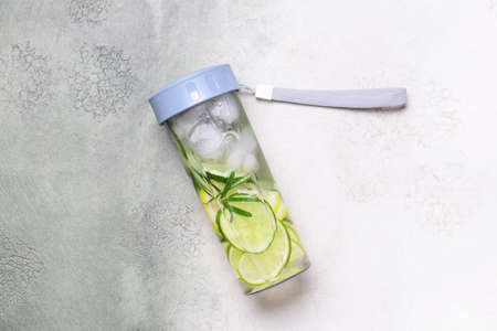 Bottle of rosemary infused water with citrus and cucumber on light backgroundの写真素材