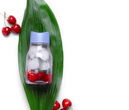 Bottle of fresh infused water with cherry on white background