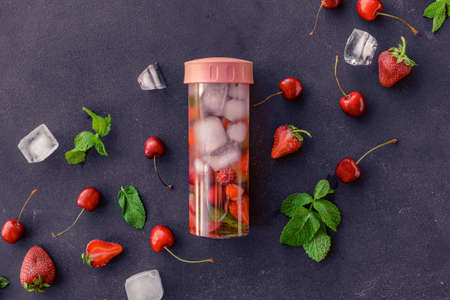 Bottle of mint infused water with berries on dark backgroundの写真素材