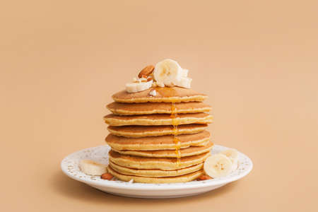 Tasty banana pancakes on color backgroundの写真素材