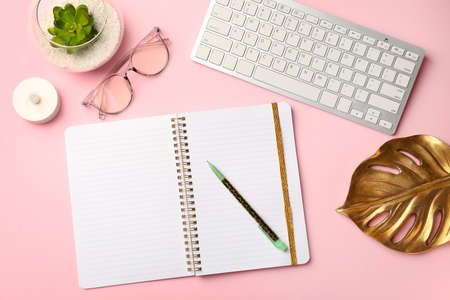 Notebook with pen and computer on color background