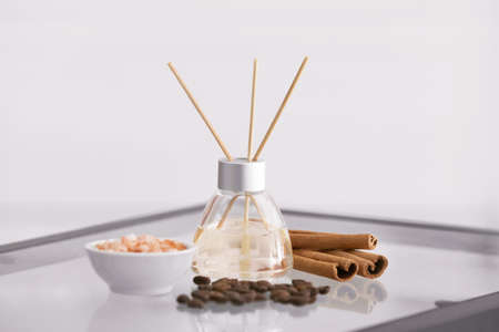 Reed diffuser, cinnamon, sea salt and coffee beans on tableの写真素材