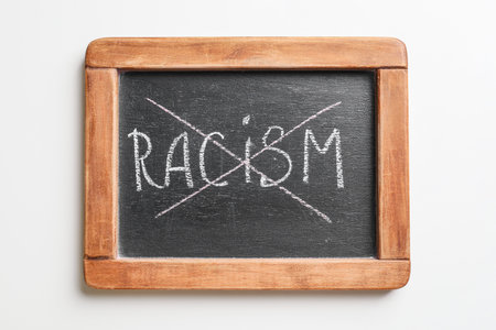 Chalkboard with crossed out word RACISM on white backgroundの写真素材