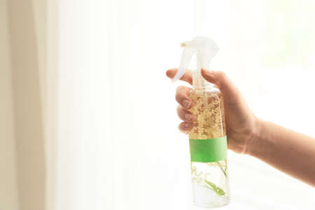 Woman using natural air freshener at home
