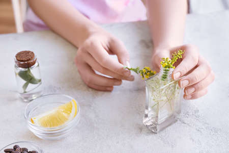 Woman making natural air freshener at tableの写真素材