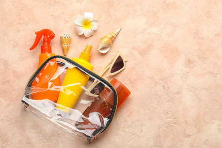 Bag with sunscreen cream and sunglasses on color backgroundの写真素材