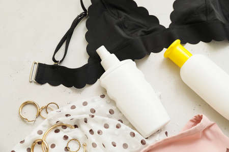 Female clothes with sunscreen cream on white background