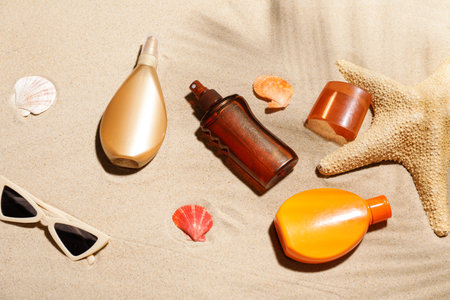 Composition with bottles of sunscreen on sand