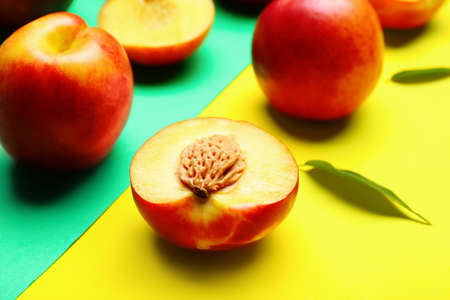 Sweet ripe nectarines on color background