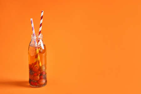Bottle of fresh ice tea on color background