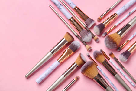 Set of makeup brushes on color background