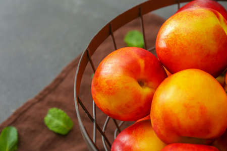 Sweet ripe nectarines in basket, closeupの写真素材