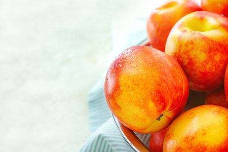 Sweet ripe nectarines in colander on table, closeupの写真素材