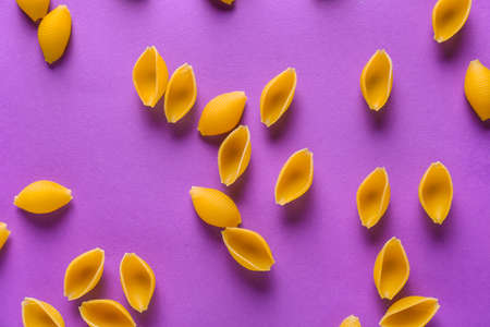 Dry conchiglie pasta on color backgroundの写真素材