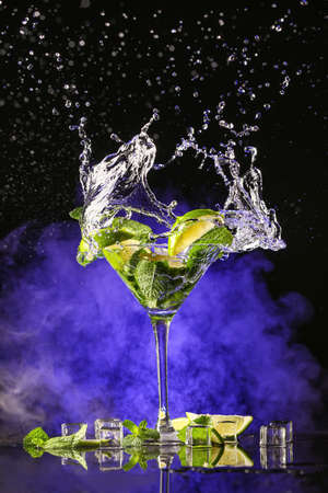 Glass of fresh mojito with splash on dark backgroundの写真素材