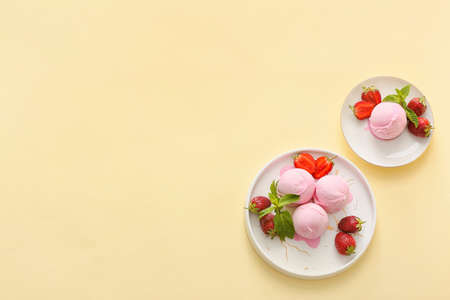 Plates with tasty strawberry ice cream on color backgroundの写真素材