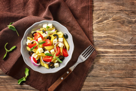 Bowl with tasty pasta salad on tableの写真素材