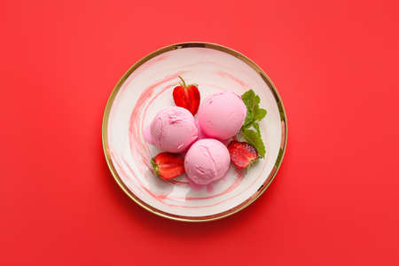 Plate with tasty strawberry ice cream on color background