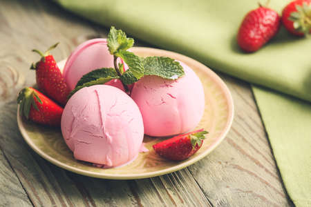 Plate with tasty strawberry ice cream on table