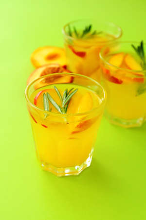 Glasses of fresh peach mojito cocktail on color backgroundの写真素材