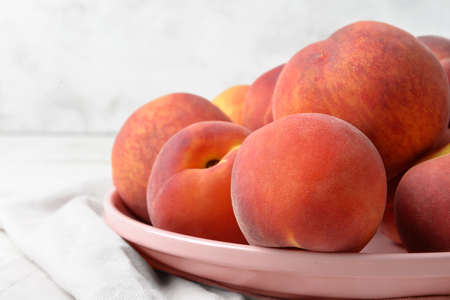 Plate with sweet peaches on table, closeup