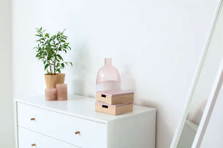 Modern chest of drawers near white wall in roomの写真素材