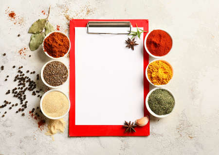 Spices and blank clipboard on white tableの写真素材