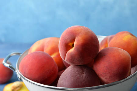 Sweet peaches in colander on table, closeupの写真素材