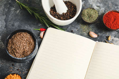 Notebook for recipes and spices on gray tableの写真素材