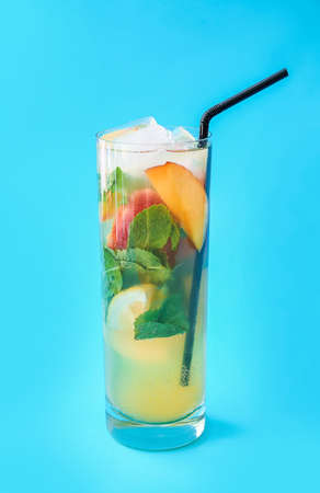 Glass of fresh fruit mojito cocktail on color backgroundの写真素材
