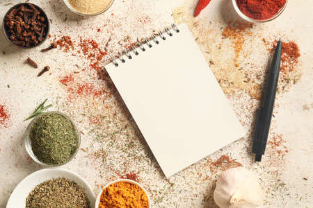 Spices and notebook for recipes on white backgroundの写真素材