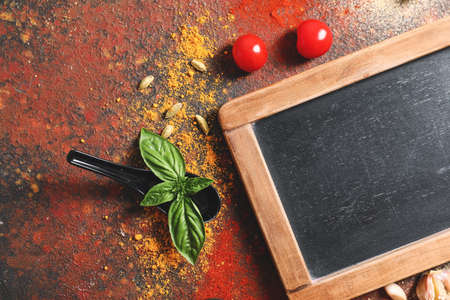 Black board, spices and herbs on tableの写真素材