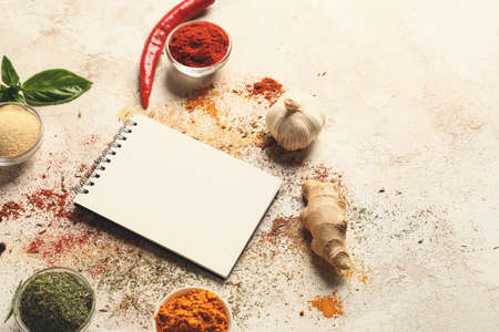 Spices and notebook for recipes on white backgroundの写真素材