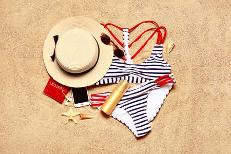 Set of beach accessories on sand, top viewの写真素材