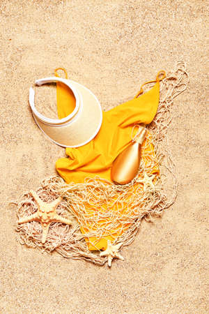 Set of beach accessories on sand, top view