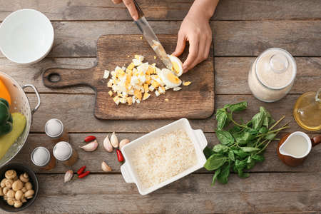 Woman cooking rice casserole on table, top viewの写真素材