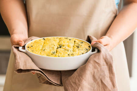 Woman with tasty rice casserole in kitchen, closeupの写真素材