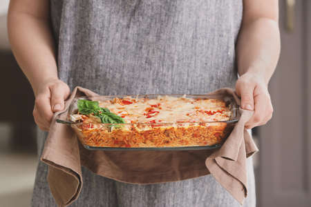 Woman with tasty rice casserole in kitchen, closeupの写真素材