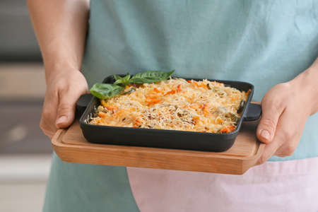 Woman with tasty rice casserole in kitchen, closeupの写真素材