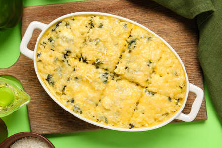 Baking dish with tasty rice casserole on color background