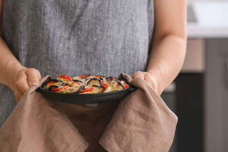 Woman with tasty rice casserole in kitchen, closeupの写真素材