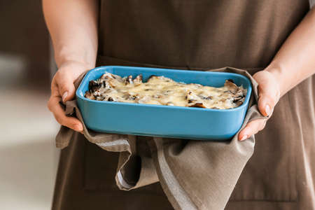 Woman with tasty rice casserole in kitchen, closeupの写真素材
