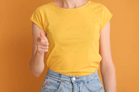 Young deaf mute woman using sign language on color backgroundの写真素材
