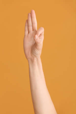 Hand showing letter F on color background. Sign language alphabetの写真素材