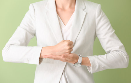 Young deaf mute woman using sign language on color backgroundの写真素材