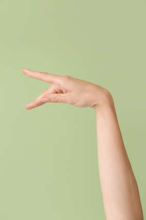 Hand showing letter P on color background. Sign language alphabet
