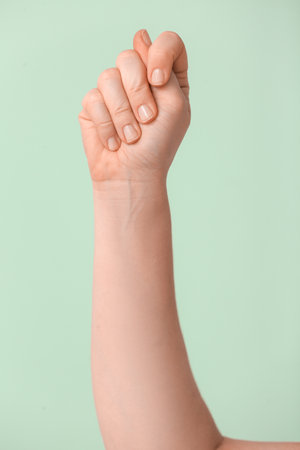Hand showing letter T on color background. Sign language alphabetの写真素材